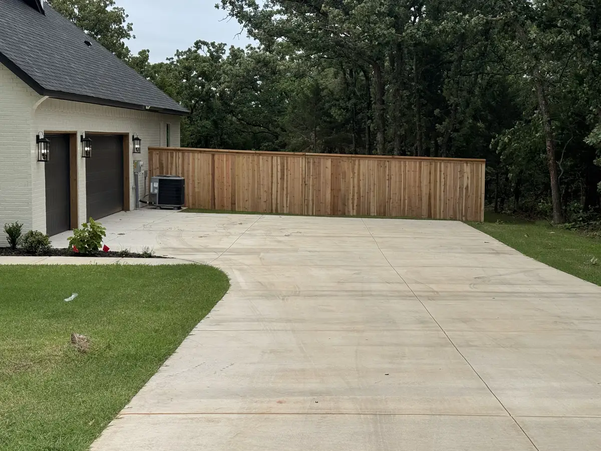 Cedar privacy fence running alongside the driveway of a modern Oklahoma City home
