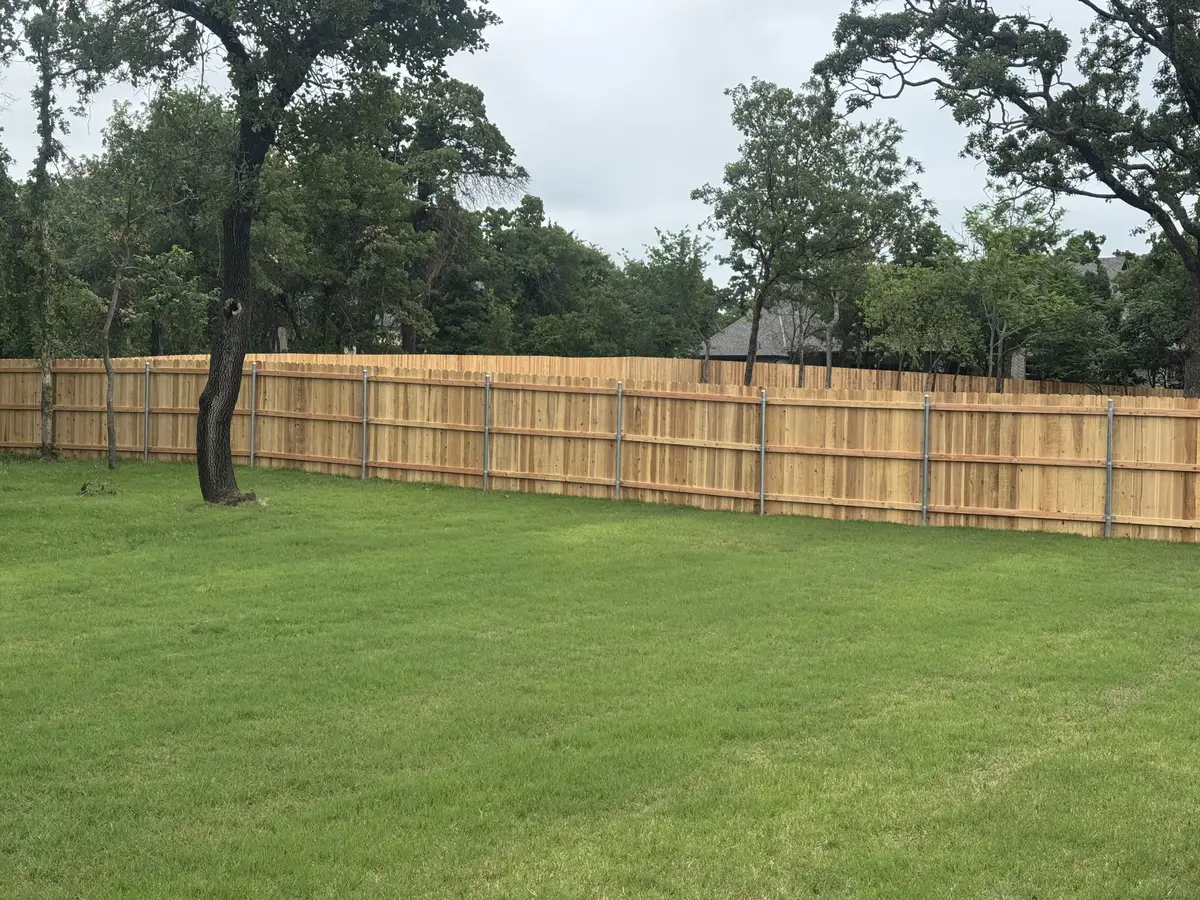 Cedar privacy fence enclosing a large tree-lined lot in the Oklahoma City metro