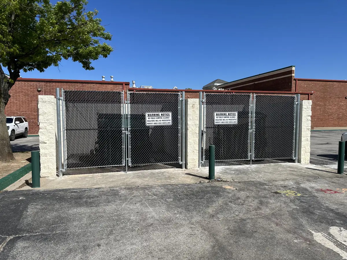 Commercial chain link double gates with privacy slats at an Oklahoma City business