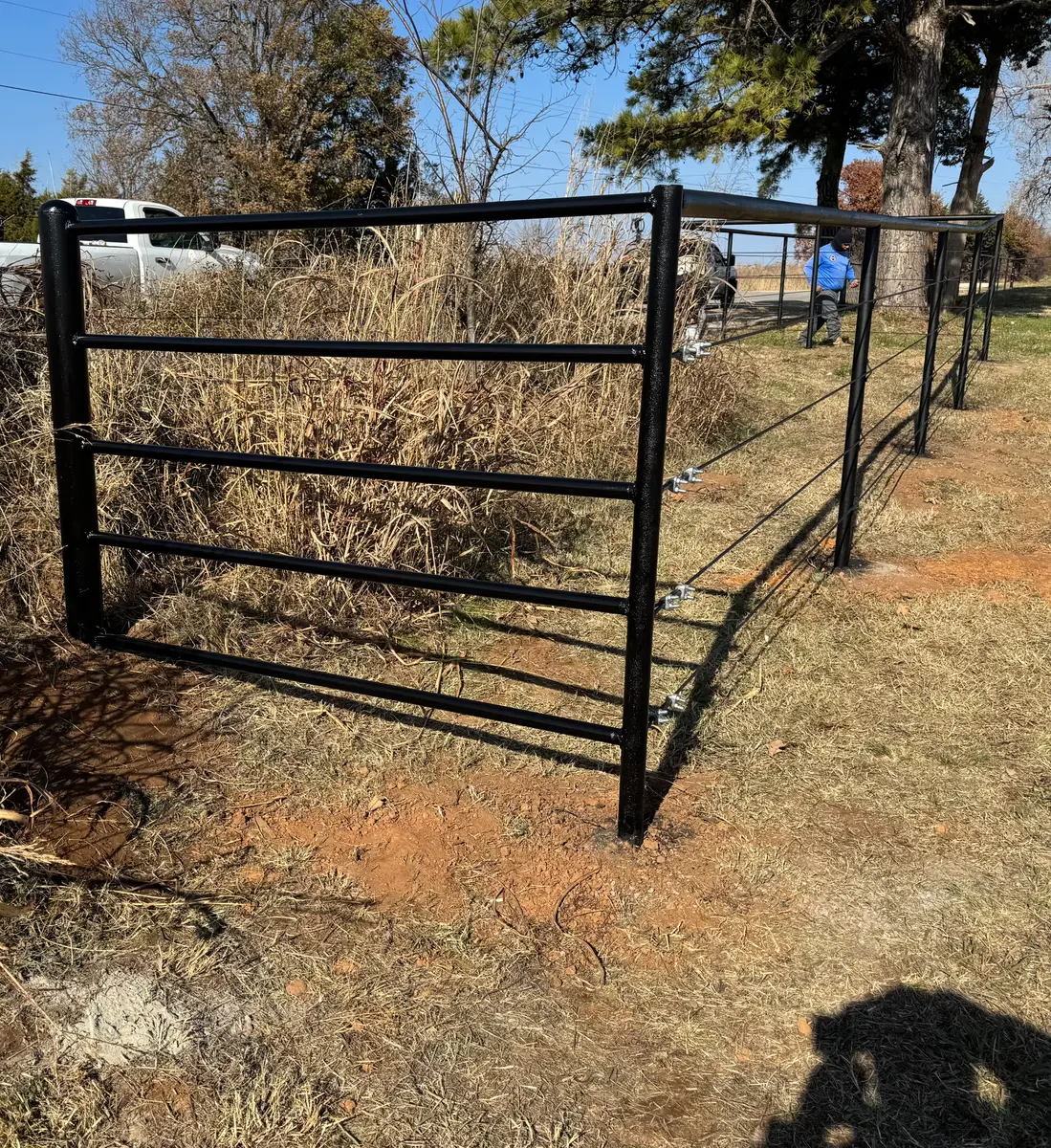 Black pipe rail corner with high-tensile wire farm fence on an Oklahoma acreage