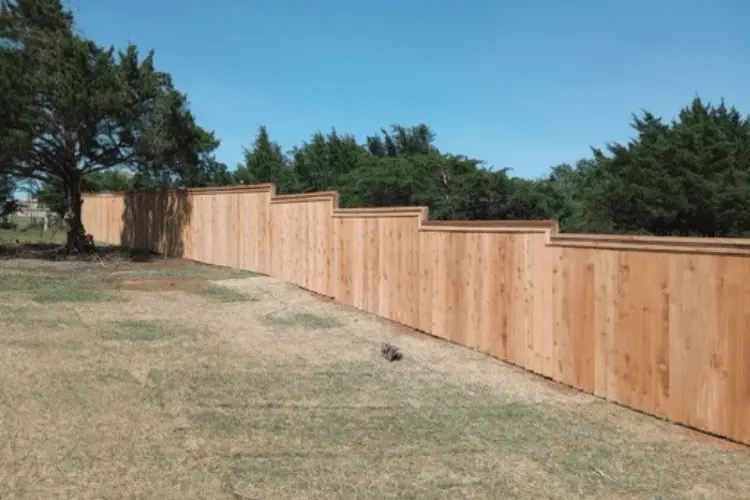 Evenly spaced wood fence posts set in concrete in Oklahoma City