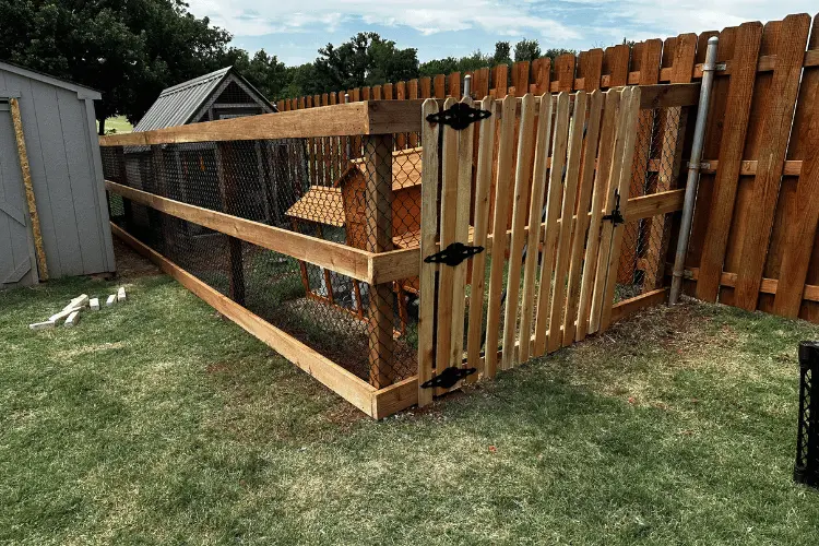 Chain link fence with a wood top rail around a yard in Oklahoma City